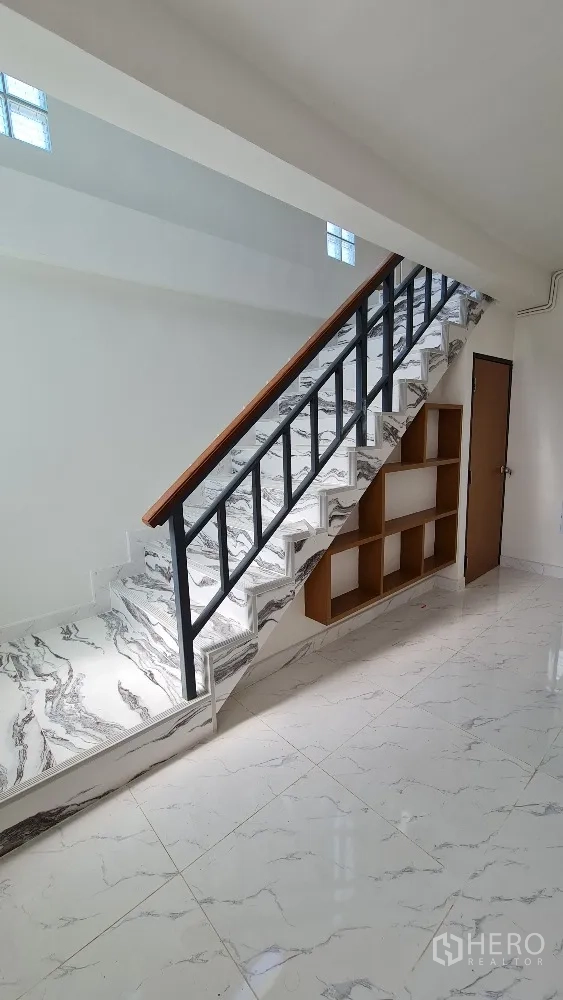 Detached House for rent in Lat Phrao, Bangkok - Feature staircase with marble-pattern steps, black railing and built-in shelving.