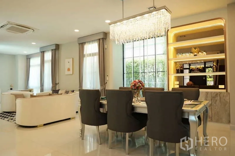 Detached House for rent or sale in Saphan Sung, Bangkok - Dining space with crystal chandelier and illuminated display shelves.