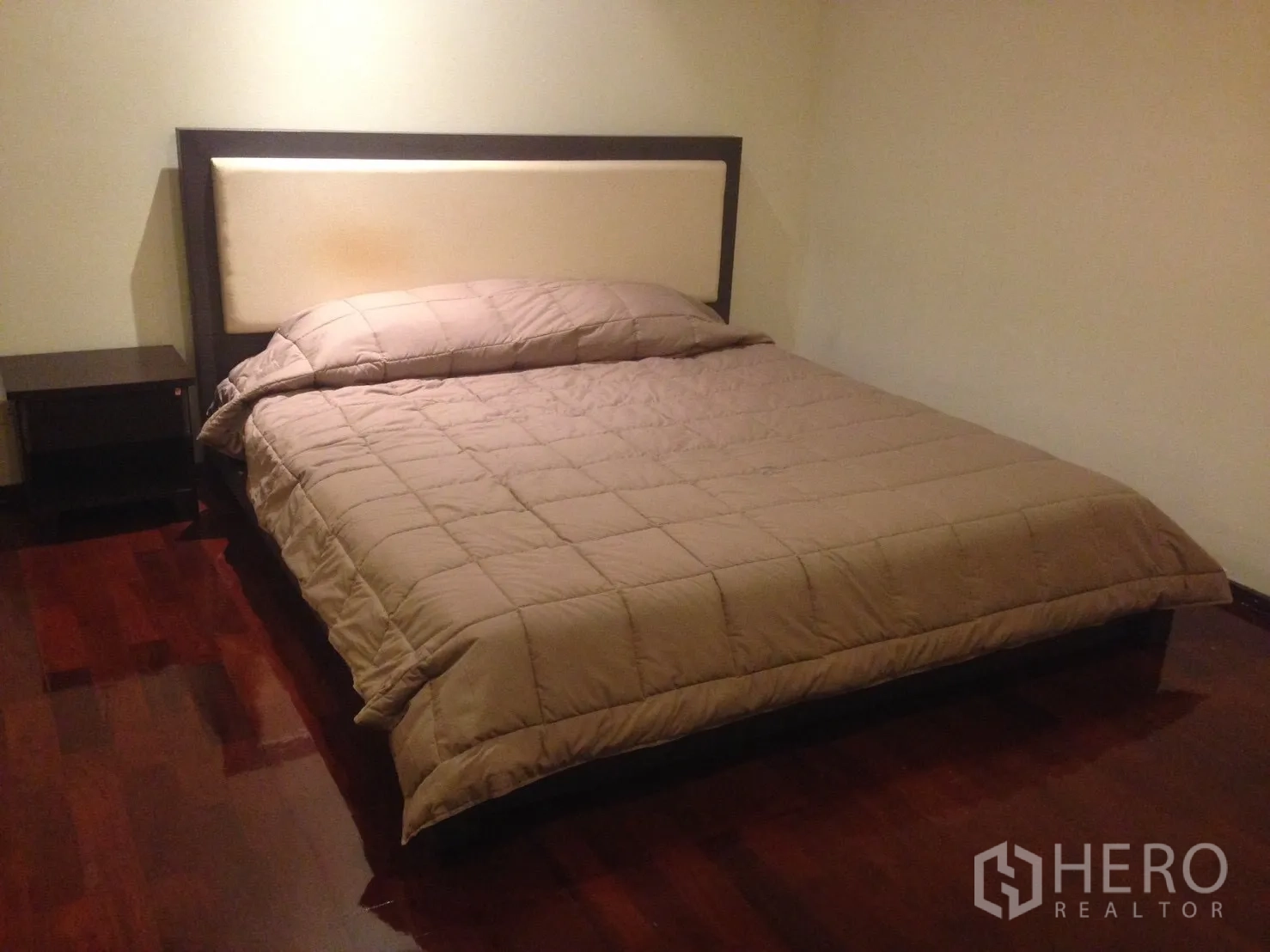 公寓 出租在Watthana, Bangkok - 第二卧室配大床、软包床头与床头柜，木地板。