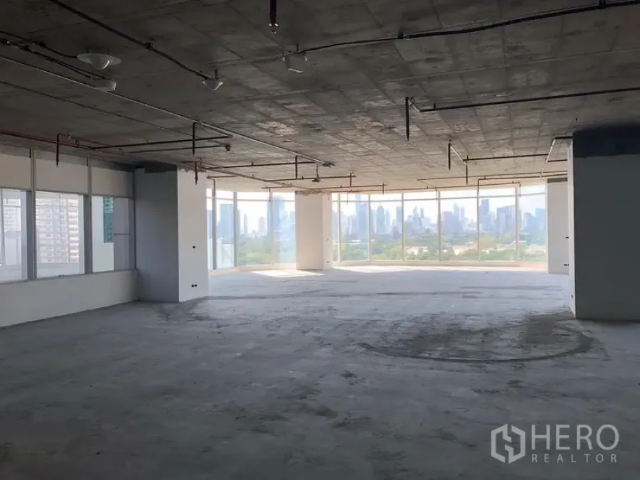 Office Space for rent in Watthana, Bangkok - Shell-and-core open-plan office floor with exposed ceiling, floor-to-ceiling windows, and panoramic Bangkok skyline views.