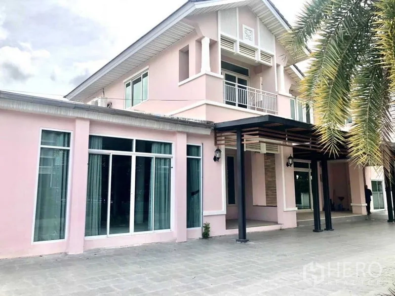 独立式住宅 出售在Lat Krabang, Bangkok - 两层粉色系独栋住宅，设大面积落地窗与带顶车棚。