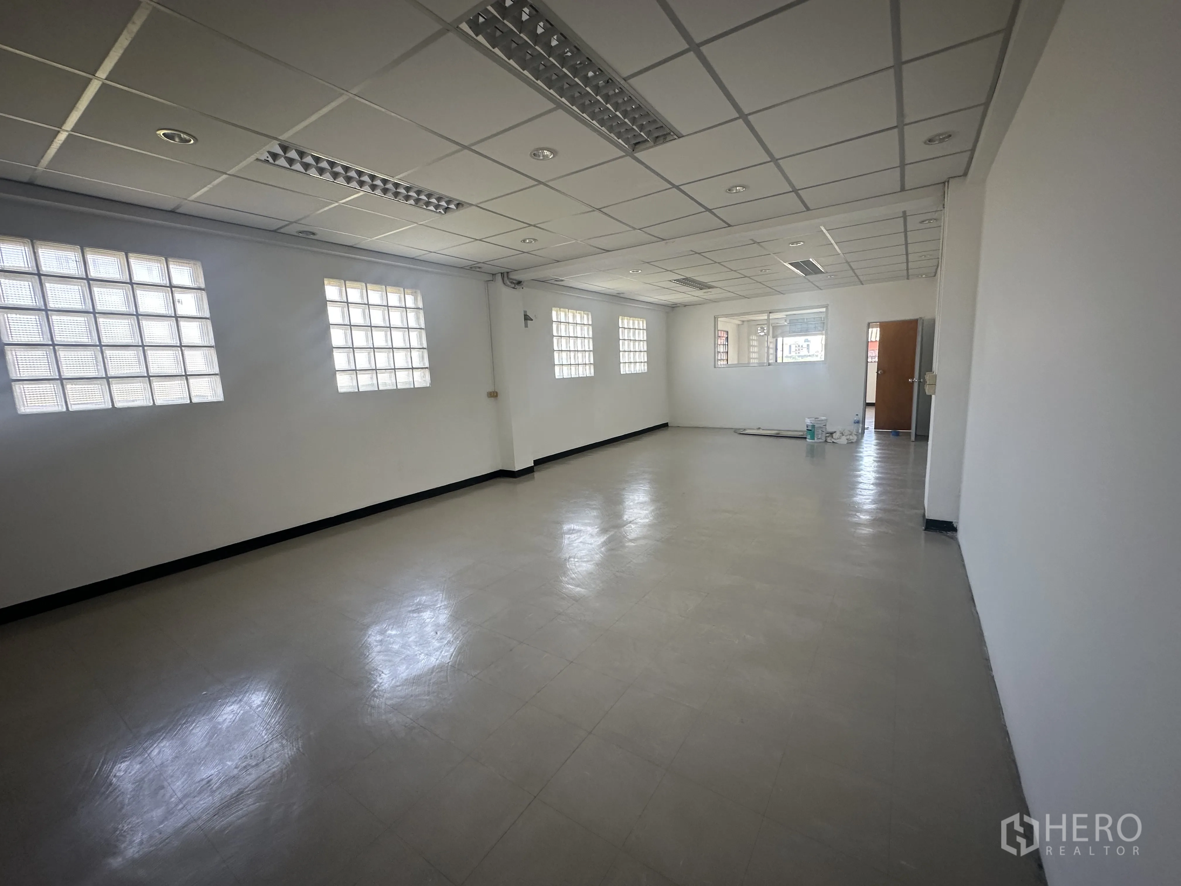 ออฟฟิศ for rent in Watthana, Bangkok - โถงสำนักงานเปิดโล่งพร้อมช่องแสงบล็อกแก้วหลายบาน ไฟเพดาน และพื้นไวนิลสะอาด