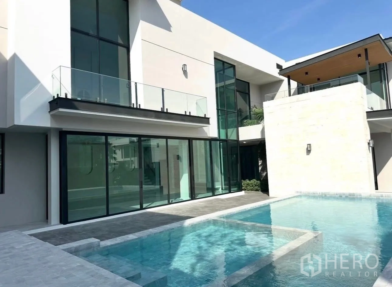 บ้านเดี่ยว for sale in Bang Khen, Bangkok - ด้านหน้าบ้านสองชั้นสไตล์ร่วมสมัย ผนังกระจก ระเบียง และสระส่วนตัว