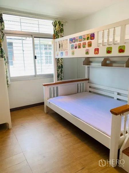 Townhouse for rent or sale in Huai Khwang, Bangkok - Children’s bedroom with a white bunk bed, window and wood flooring