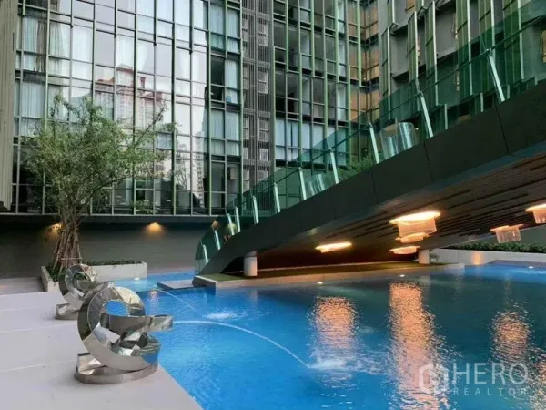 公寓 出售在Ratchathewi, Bangkok - 曼谷拉差贴威公寓的现代泳池，带空中步桥和雕塑座椅。