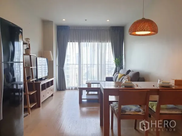 公寓 出租或出售在Bangkok - 明亮的客餐厅一体空间，落地窗、木质家具与城市景观。