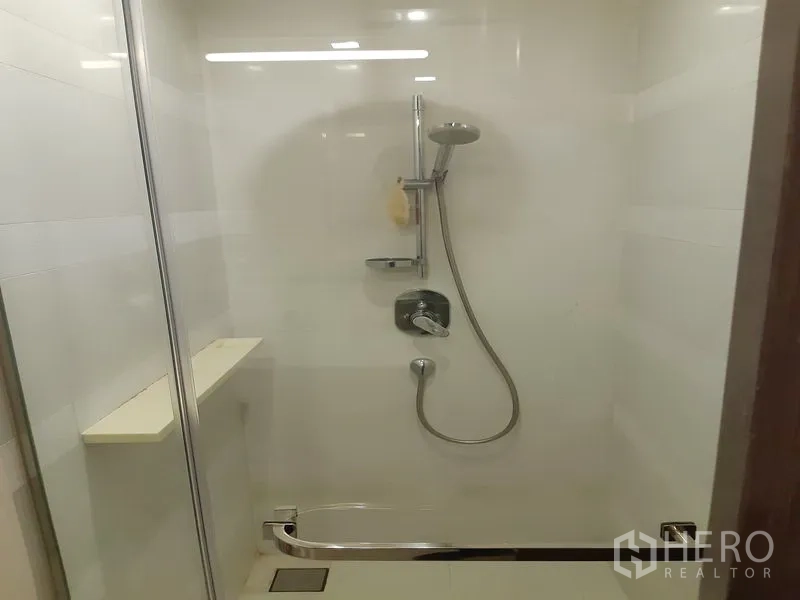 Condominium for sale in Khlong Toei, Bangkok - Glass-enclosed shower with handheld showerhead and built-in shelf.