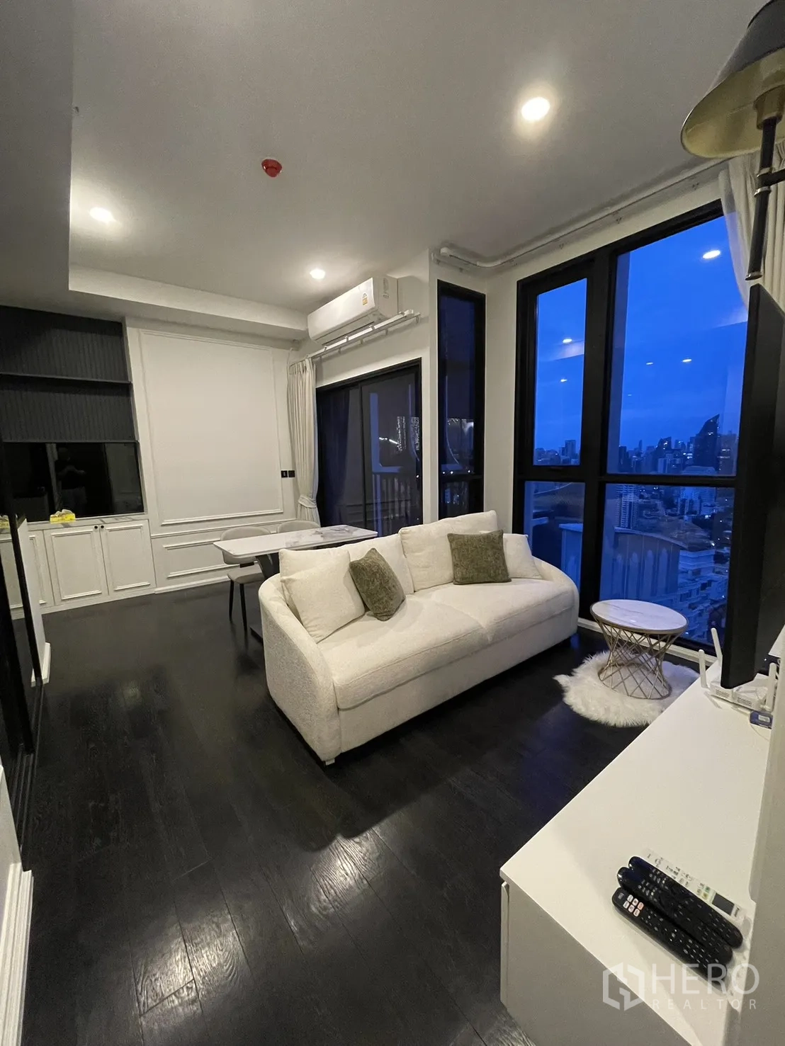 公寓 for rent in Watthana, Bangkok - 明亮客厅设沙发与大窗户，可观赏夜色天际线。