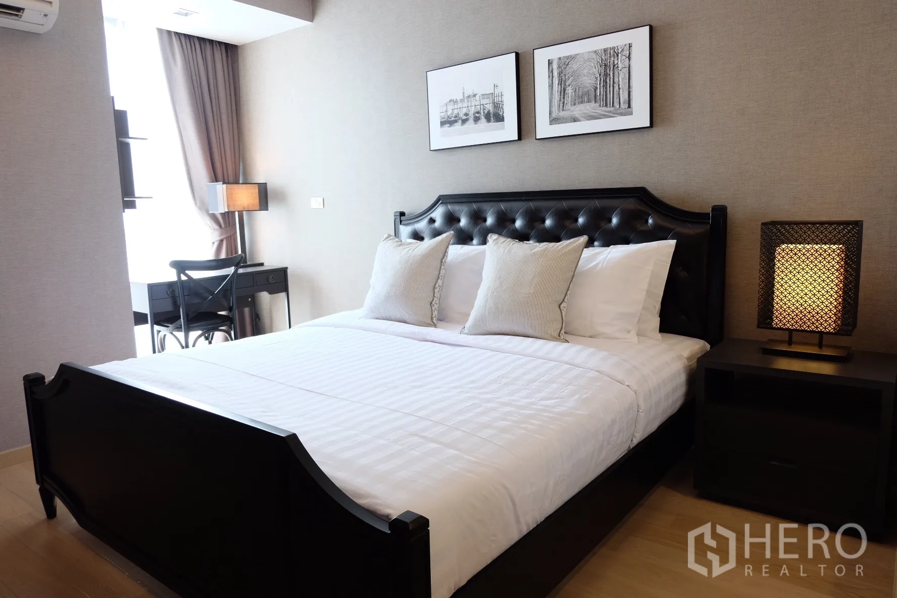 Condominium for rent in Watthana, Bangkok - Master bedroom featuring a tufted headboard bed, bedside lamp, and work desk by the window.