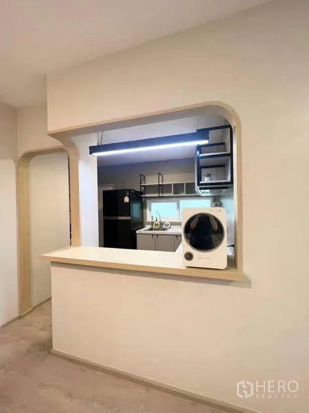 独立式住宅 出租在Prawet, Bangkok - 厨房传菜窗口与吊灯，可望见整体橱柜。