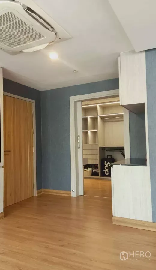 Detached House for rent or sale in Khan Na Yao, Bangkok - Bright room with wood flooring, blue walls, cassette ceiling A/C and doorway to built‑in walk‑in closet.