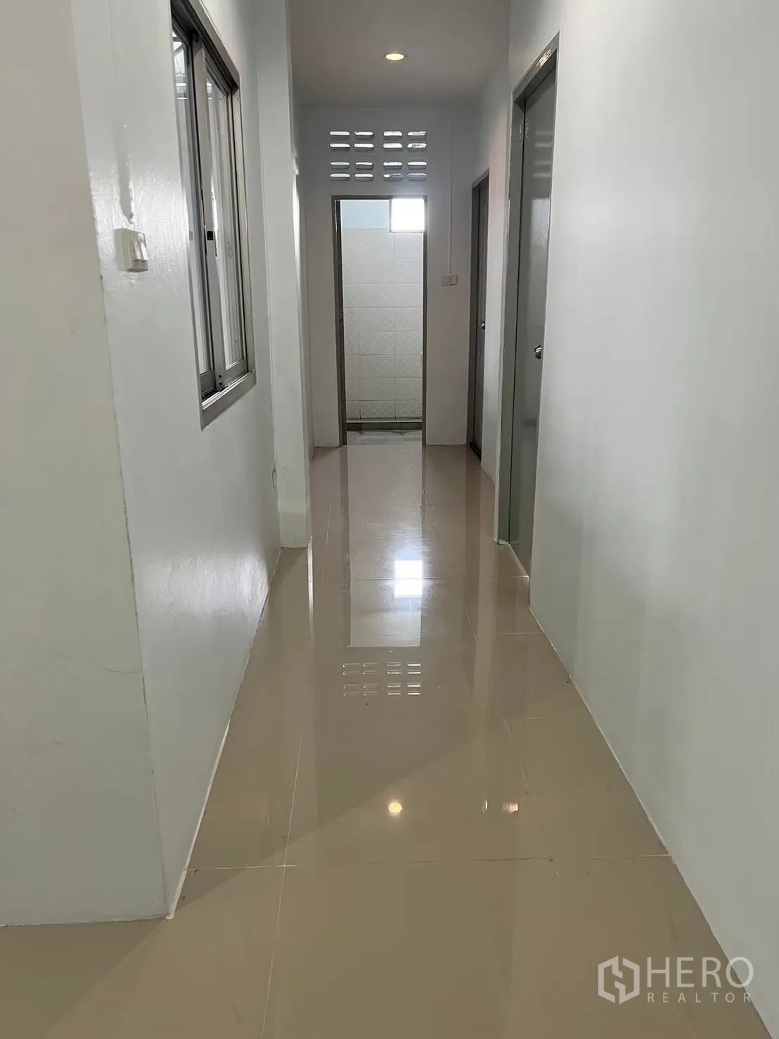 Factory for rent in Bang Bua Thong, Nonthaburi - Hallway with glossy floor leading to restrooms and offices.