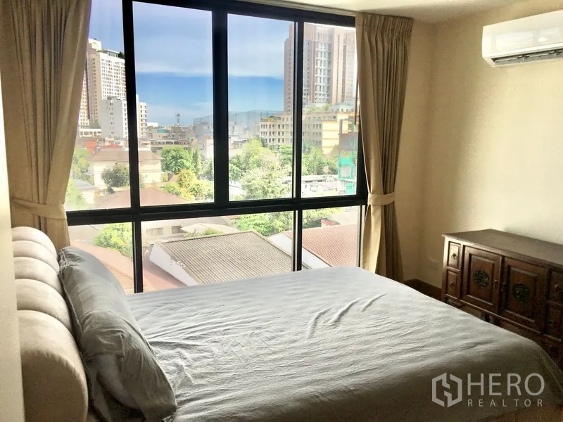 Condominium for rent in Watthana, Bangkok - Second bedroom with floor-to-ceiling windows and city outlook.