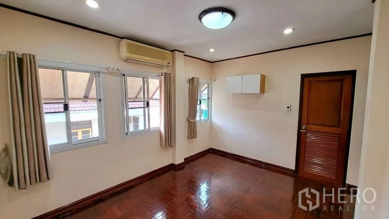 联排别墅 出租在Watthana, Bangkok - 卧室，三扇窗配窗帘，空调与木地板
