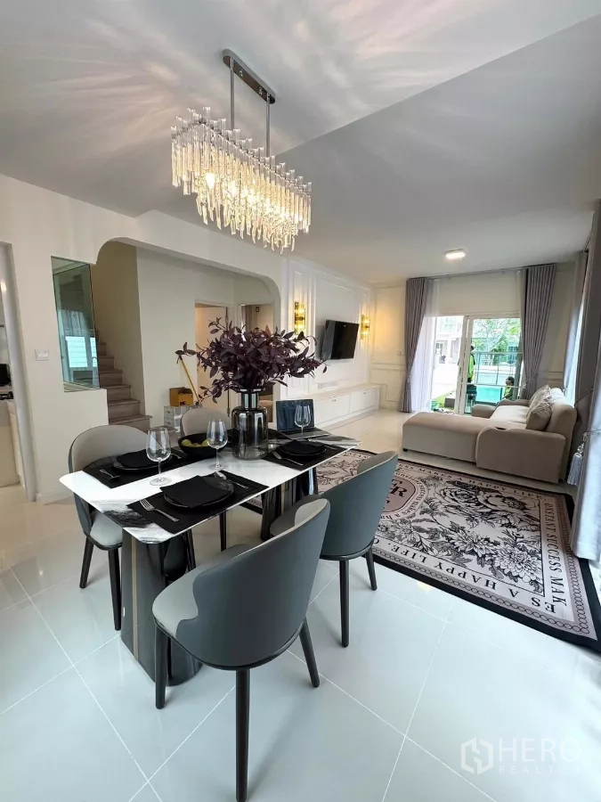 Detached House for rent in Bang Phli, Samut Prakan - Dining table for six under a crystal chandelier next to the staircase.