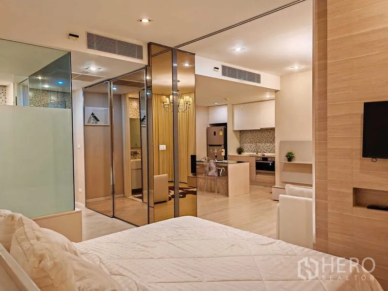 公寓 出租在Watthana, Bangkok - 卧室带镜面衣柜与玻璃隔断，通向厨房