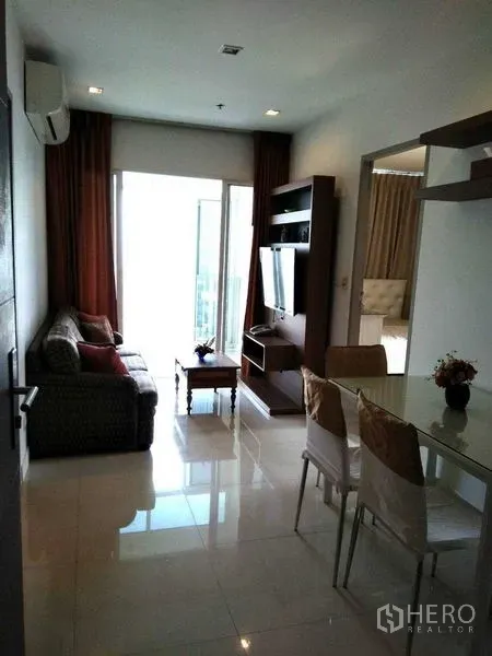 公寓 出租在Watthana, Bangkok - 客餐厅一体，连接明亮阳台，自然采光充足。