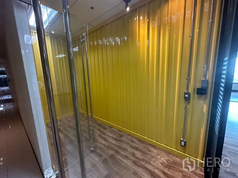 Office Space for rent in Chatuchak, Bangkok - Entry lobby with yellow feature wall, exposed conduits, and clear glass doors.