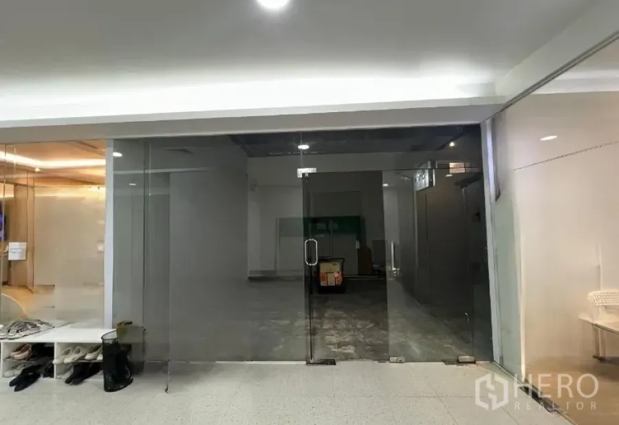 Retail Space for rent - Vacant retail unit with full-height glass storefront and double doors opening to an indoor corridor.