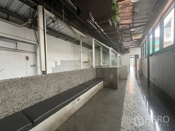 Retail Space for rent in Bang Rak, Bangkok - Industrial-style retail corridor with granite counter, glass partitions, bench seating and exposed ceiling.