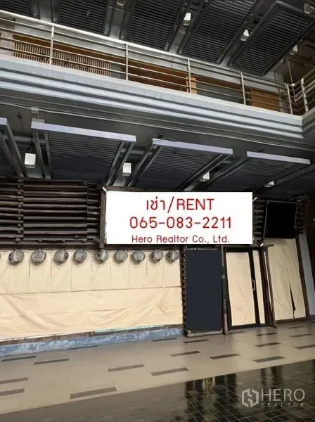 Retail Space for rent - Double-height retail storefront with louvered ceiling, glass entry and tiled floor in an indoor commercial area.