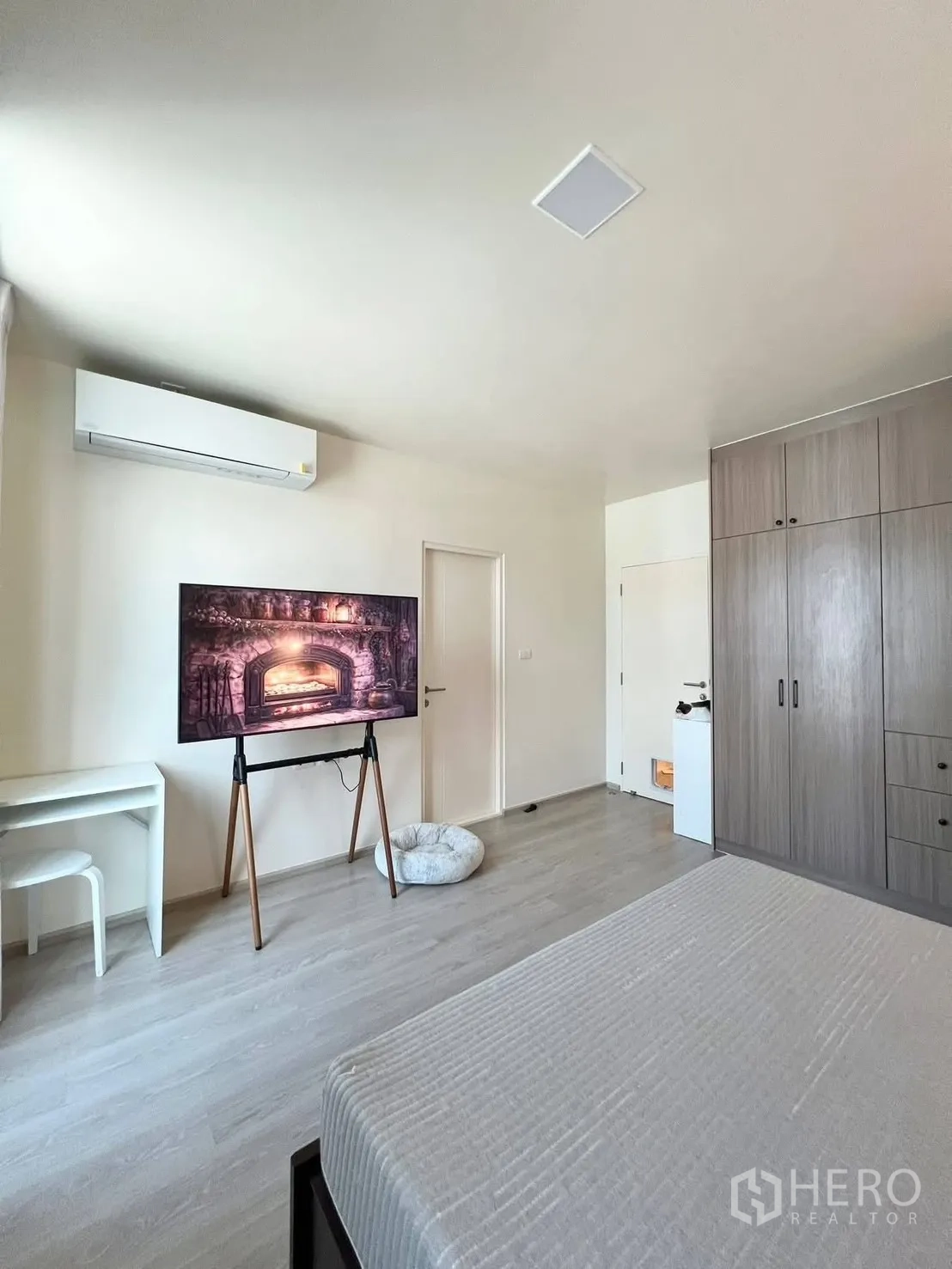 ทาวน์เฮาส์ for rent in Bang Phli, Samut Prakan - ภาพมุมกว้างห้องนอนหลัก เห็นทีวี โต๊ะทำงาน ตู้เสื้อผ้า และพื้นลามิเนต