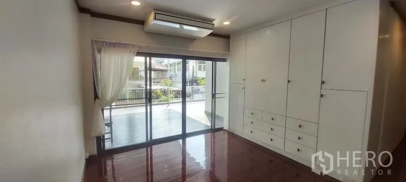 独立式住宅 出租在Pathum Wan, Bangkok - 卧室带嵌入式衣柜，推拉大门连接露台