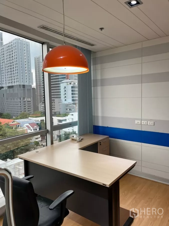 Office Space for rent in Khlong Toei, Bangkok - Executive corner office with an L-shaped desk, orange pendant light and city view.