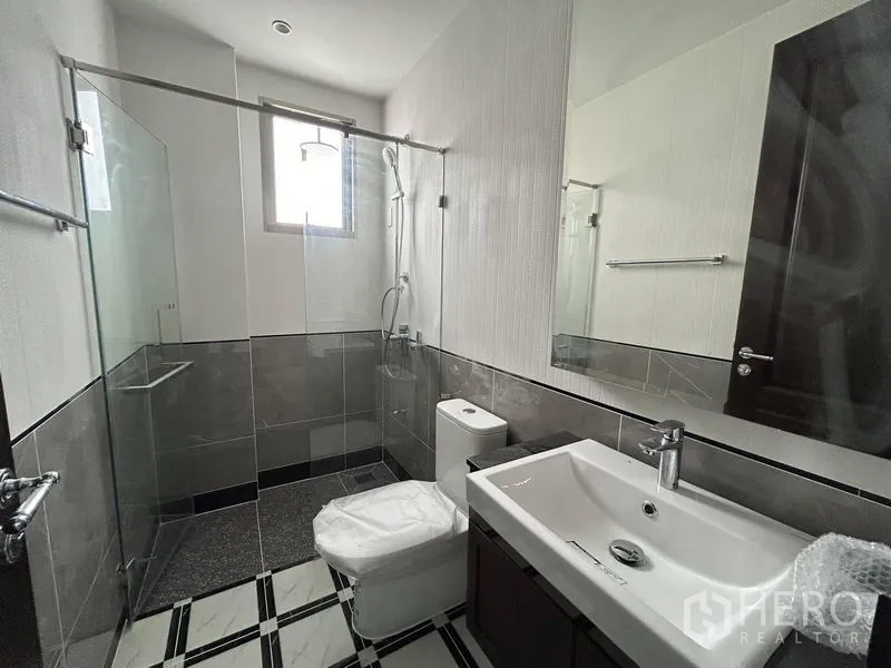 Detached House for rent or sale - Guest bathroom with glass shower enclosure, vanity and toilet.