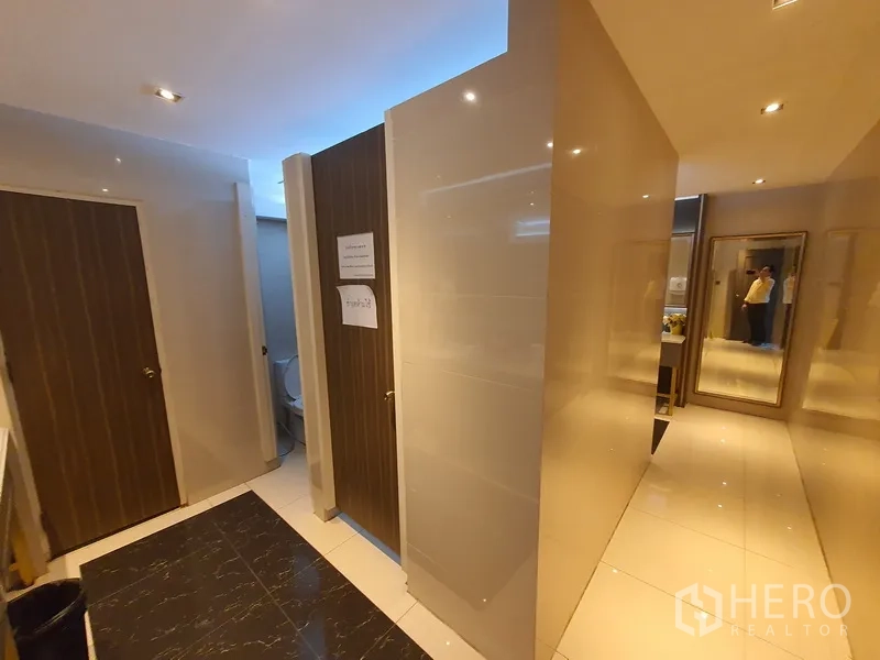 Office Space for rent in Khlong Toei, Bangkok - Restroom corridor with tiled walls and multiple cubicle doors.