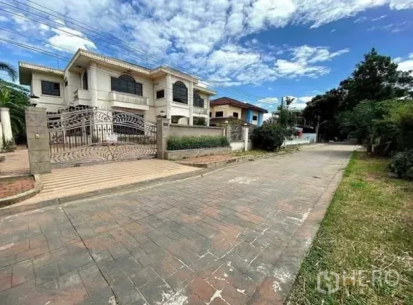 Detached House for sale in Prawet, Bangkok - Street view of the gated entrance and two-storey house in a quiet neighborhood.