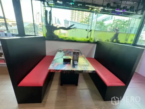零售空间 出租在Ratchathewi, Bangkok - 设有红色卡座与桌子的用餐区，旁边为观赏鱼缸。