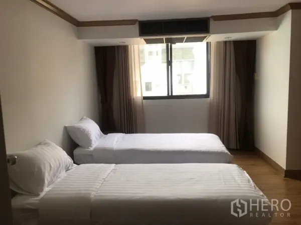 公寓 出租在Watthana, Bangkok - 次卧配两张单人床，木地板，带窗与窗帘。