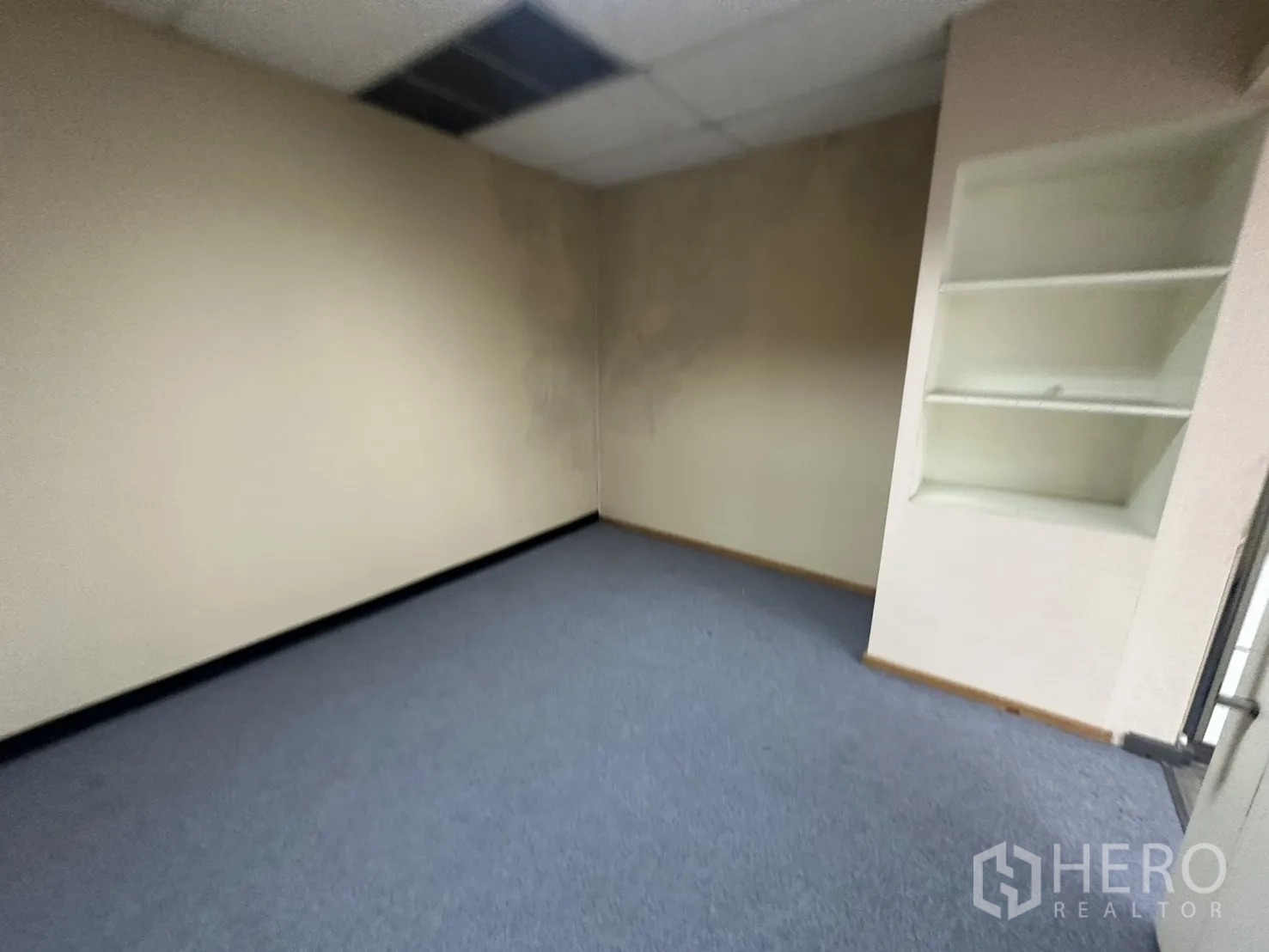 Office Space for rent in Bang Rak, Bangkok - Compact carpeted private office with built-in wall shelving.