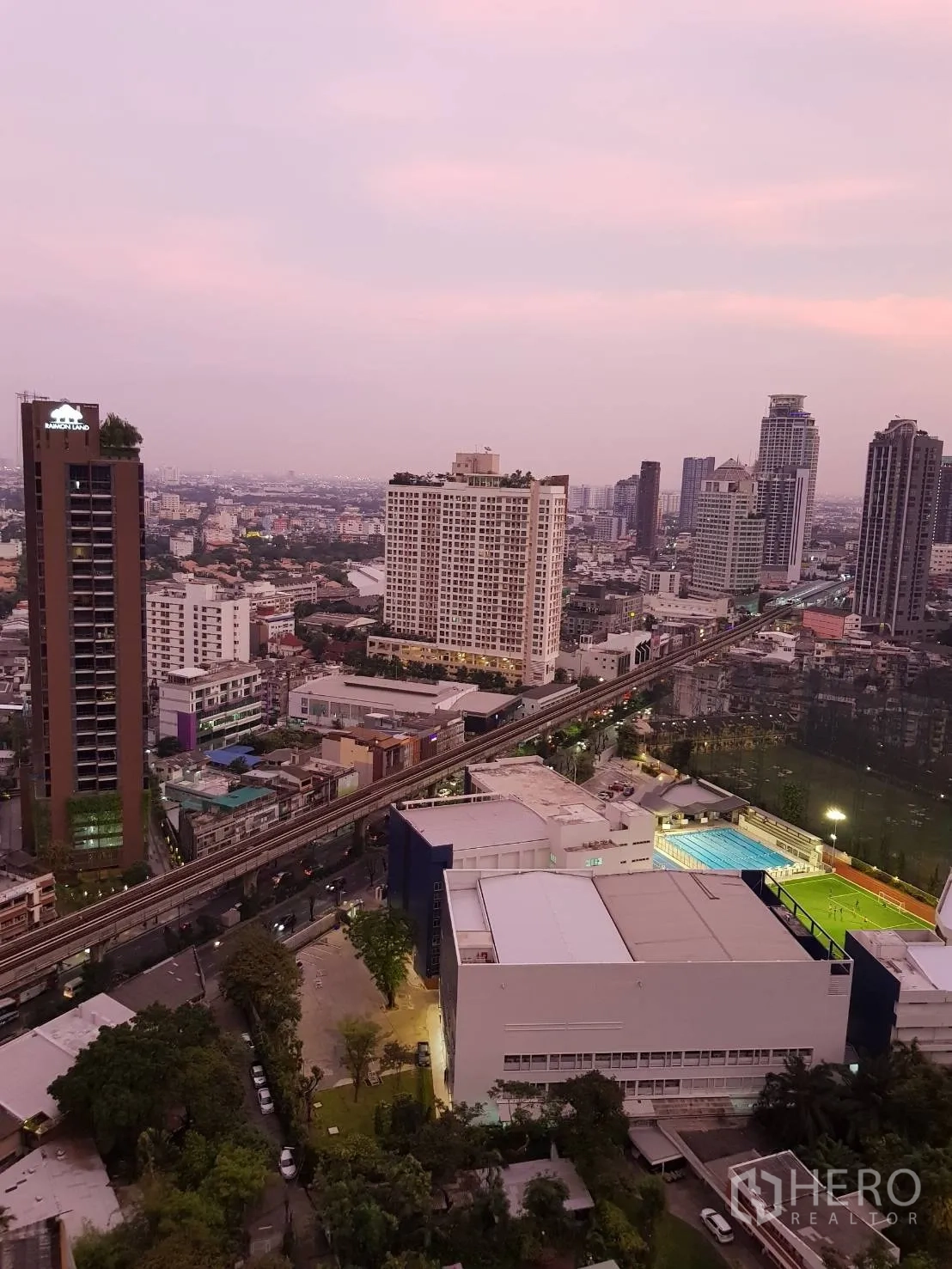 Condominium for rent in Khlong Toei, Bangkok - High-floor city view over Ekkamai showing BTS Skytrain tracks and a sports field.