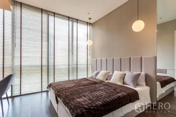 Condominium for rent in Khlong Toei, Bangkok - Bright bedroom with floor-to-ceiling blinds, twin bed setup and pendant lights.