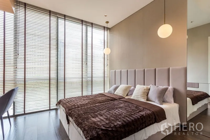 Condominium for rent in Khlong Toei, Bangkok - Bright bedroom with floor-to-ceiling blinds, twin bed setup and pendant lights.