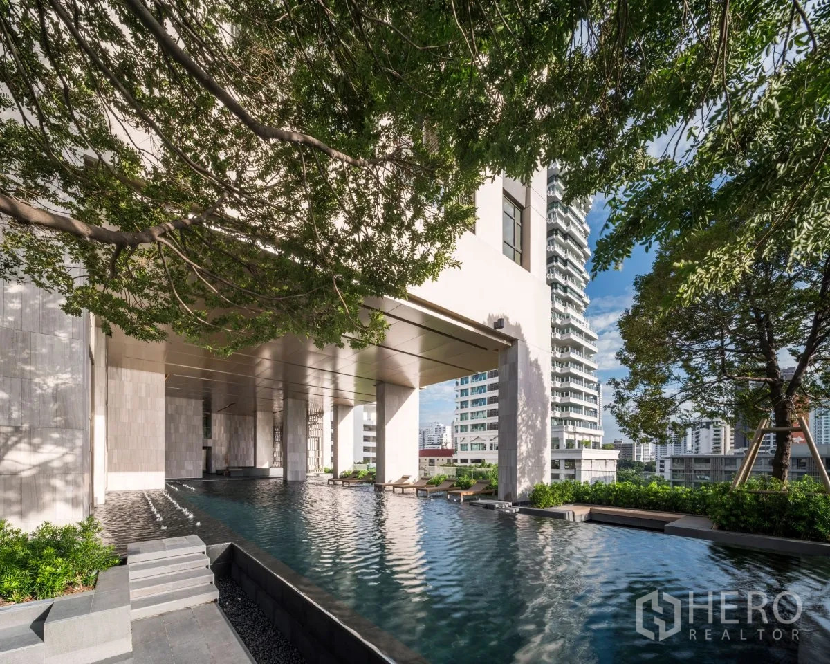 公寓 出租或出售在Watthana, Bangkok - 公寓户外泳池配躺椅与绿化，可欣赏城市景观。