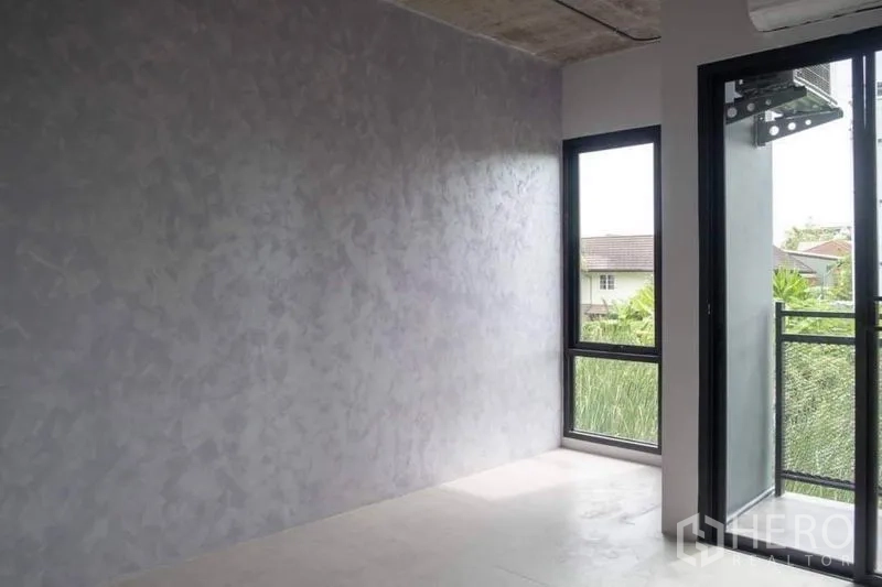 Home Office for rent or sale in Lak Si, Bangkok - Compact room opening to a small balcony through a sliding glass door.