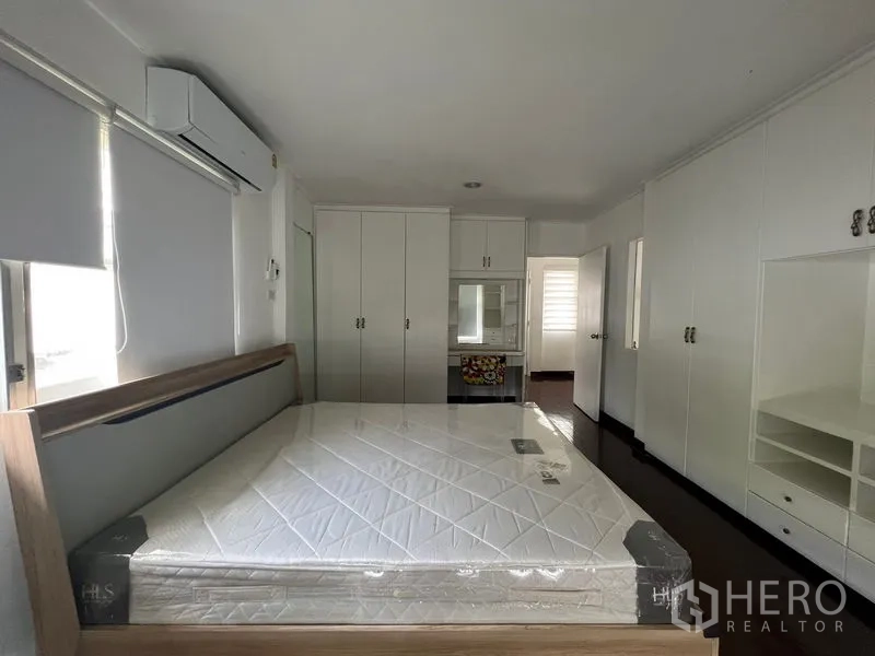 Detached House for rent in Saphan Sung, Bangkok - Master bedroom with new mattress, ample white cabinets and air conditioning.
