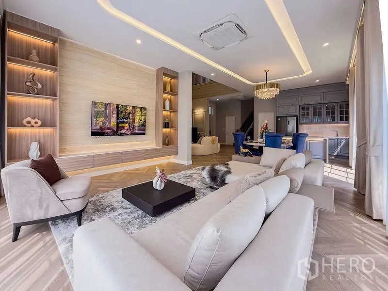 Detached House for rent or sale in Bang Kapi, Bangkok - Open-plan living and dining area with TV feature wall and fitted kitchen.