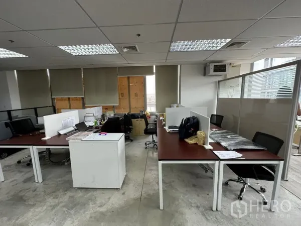 Office Space for rent in Khlong Toei, Bangkok - Work area with partitioned desks, rolling chairs and window blinds under fluorescent lighting.