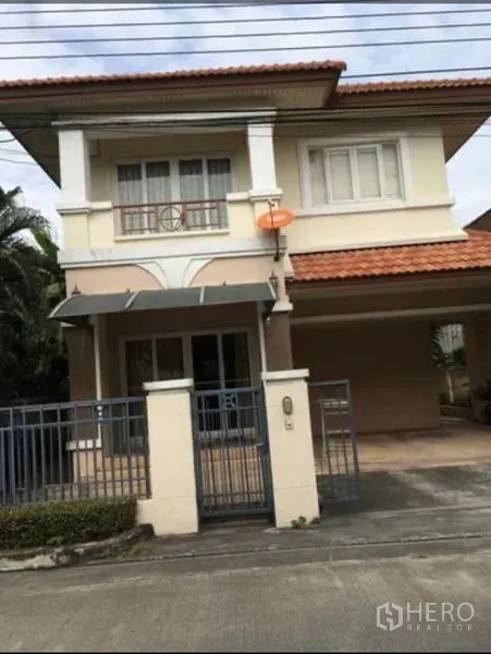 Detached House for rent in Bang Kapi, Bangkok - Two-storey detached house with terracotta roof, gated entry and a covered carport.
