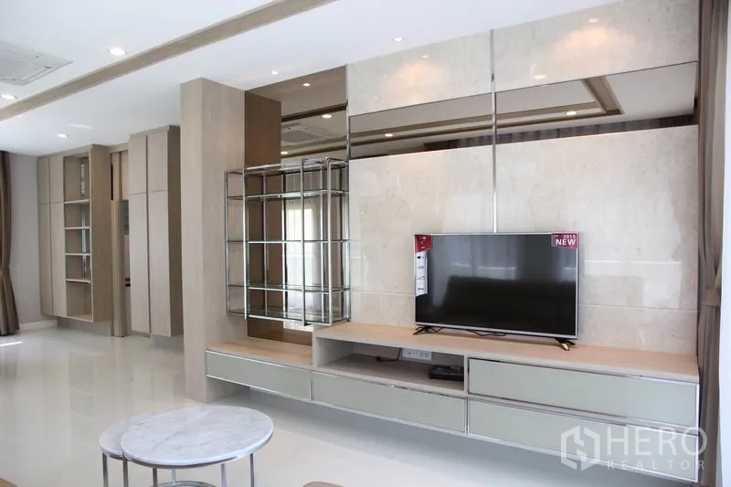 บ้าน ให้เช่าในBang Na, Bangkok - ห้องนั่งเล่นโปร่งสว่าง ผนังตกแต่งเงาวาว พร้อมตู้วางทีวีและชั้นโชว์แบบบิลท์อิน