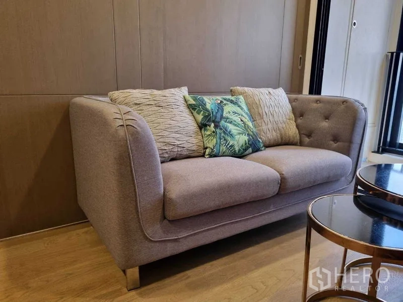 Condominium for rent in Bang Rak, Bangkok - Close-up of plush two-seat sofa with patterned cushions.
