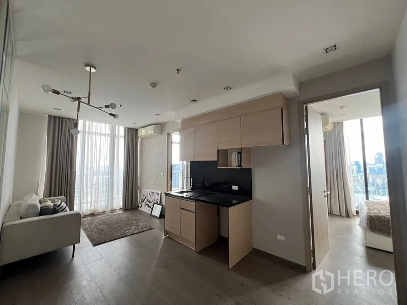 Condominium for sale - Open-plan living and kitchen with tall windows and doors to both bedrooms.