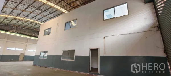 Factory for rent in Khlong Luang, Pathum Thani - Spacious warehouse interior with high steel-truss roof and internal two-storey office.