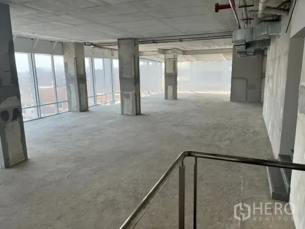 办公空间 出租在Sathon, Bangkok - 壳体交付的开放式办公楼层，混凝土立柱、外露风管与落地窗，靠近BTS Chong Nonsi。