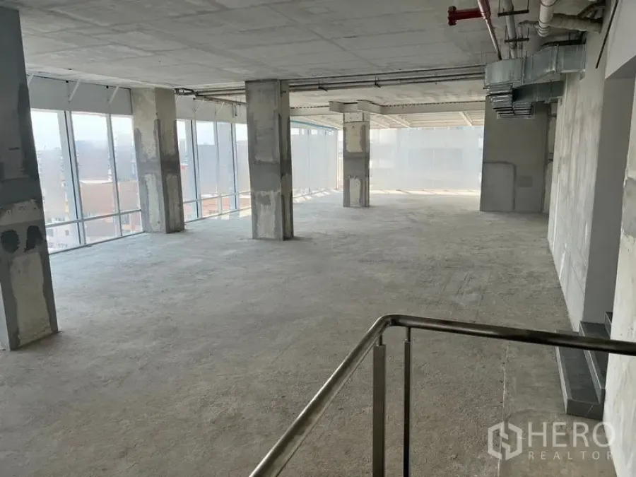 办公空间 出租在Sathon, Bangkok - 壳体交付的开放式办公楼层，混凝土立柱、外露风管与落地窗，靠近BTS Chong Nonsi。