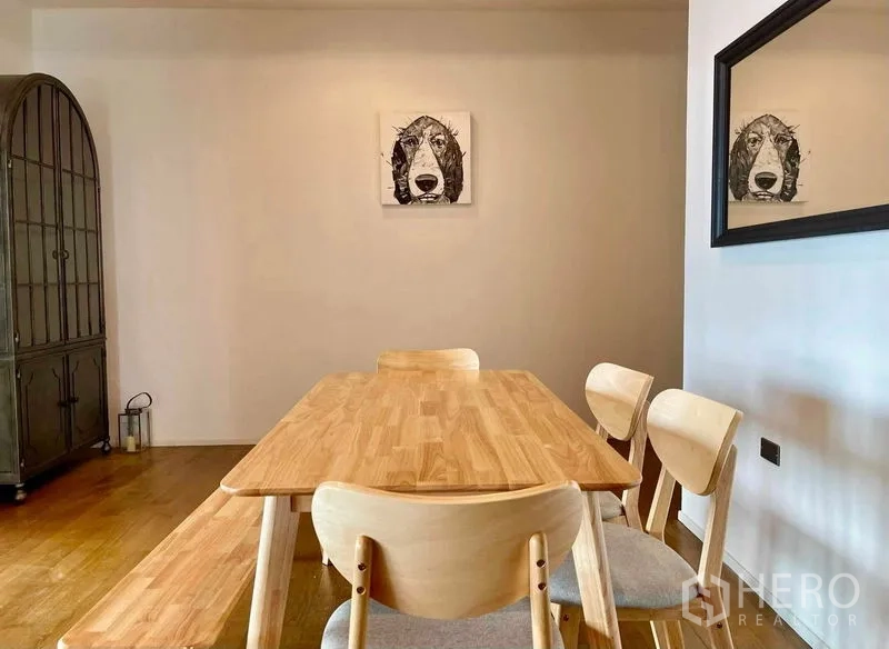 公寓 出租在Watthana, Bangkok - 用餐角落，木质餐桌椅与墙面装饰画。